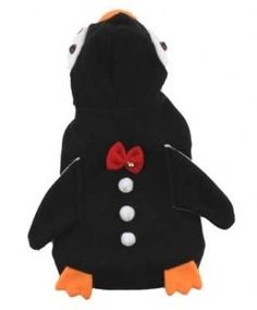 a stuffed penguin wearing a red bow tie and black jacket with white polka dots on its chest