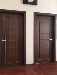 two brown doors in front of a clock on the wall