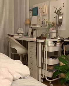 a bedroom with a bed, desk and plants