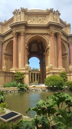 an ornate building surrounded by greenery and water