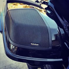 the back end of a black motorcycle parked in a parking lot