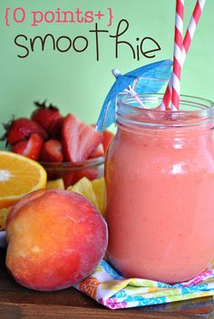 a smoothie in a mason jar with strawberries and oranges on the side