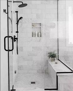 a walk in shower sitting next to a white bath tub under a bathroom window with black trim