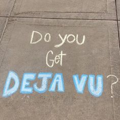 the words do you get deta vu written in blue chalk on a concrete sidewalk