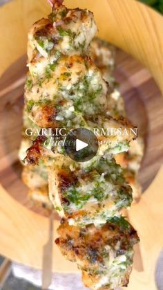 chicken skewers with broccoli and cheese on a wooden plate