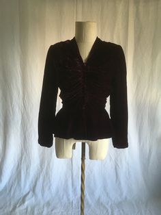 "vintage 1930s women's handmade blouse or blazer jacket dark purple velvet matching button up front (many buttons) snap front/bottom pleated detail shoulder pads purple lining, including sleeves fitted waist peplum hem hem longer at back very good vintage condition, light wear-bottom button missing (w/button loop tucked in it's un-noticable) measures, lying flat, shoulder-15 1/2\" chest-17 1/2\" sleeve-23\" natural waist-13 1/2\" top to front hem-23\" top to back hem-26 1/2\" this has a nod to Victorian era w/the peplum hem leaving room for a bustle skirt" Fitted Vintage Costume Blazer, Vintage Fitted Button-up Blazer, Vintage Fitted Blazer With Covered Buttons, Fitted Purple Blazer With Buttons, Fitted Vintage Burgundy Outerwear, Fitted Burgundy Vintage Outerwear, Fitted Velvet Long Sleeve Blazer, Dark Purple Victorian Dress, Fitted Velvet Blazer With Buttons