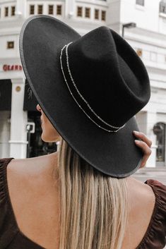 Black wide brim fedora hat finished with a delicate wrapped chain detail and ribbon trim finish. Interior adjustable size. Material: 100% Wool. This item is Final Sale. Chic Adjustable Fedora With Flat Crown, Elegant Felt Hat For Rodeo In Fall, Elegant Felt Hat For Rodeo And Fall, Elegant Flat Crown Hat, Chic Fedora With Flat Brim For Rodeo, Chic Flat Brim Fedora For Rodeo, Chic Adjustable Boater Hat For Fall, Chic Brimmed Hat As Fashion Accessory, Chic Adjustable Hat With Flat Crown