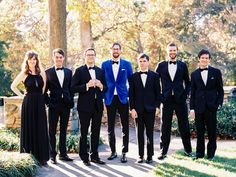 a group of men in tuxedos standing next to each other on a sidewalk