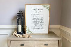 a wooden dresser with a framed menu next to a candle and some seashells