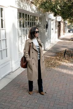 woman wearing trench coat with brown boots, brown leather bag, and striped sweater, part of french basics. Sezane Style Fall, Sezane Styling, Sezane Winter, Sezane Style, Sezane Outfit, Parisian Fall Outfits