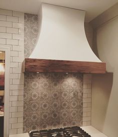 a stove top oven sitting inside of a kitchen next to a wall mounted range hood