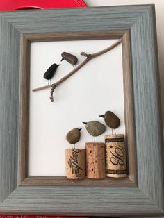 three birds sitting on top of corks in a frame