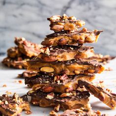 a stack of chocolate pretzels with nuts on top