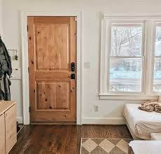 a living room with wood floors and a wooden door in the center of the room