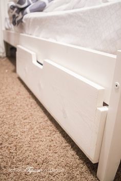 a white bed frame with two drawers on each side