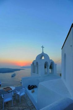 the sun is setting over an island with white buildings