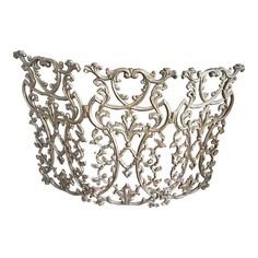 an ornate silver metal basket on a white background with clippings to the side