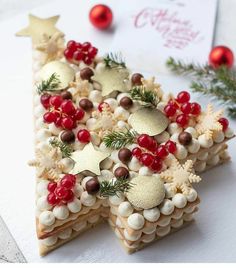 two pieces of christmas tree shaped food on top of a white surface with red and gold decorations