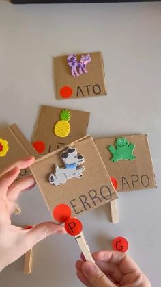 a person holding a toothpick in front of cardboard boxes with magnets on them