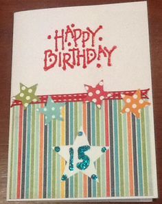 a birthday card with the number fifteen on it and stars in the middle, sitting on top of a wooden table