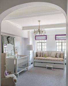 a baby's room with a white crib, couch and dresser in it