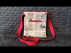 a newspaper bag sitting on top of a black bed covered in red string and fabric