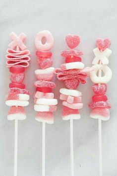 pink and white lollipops are arranged on top of each other with hearts