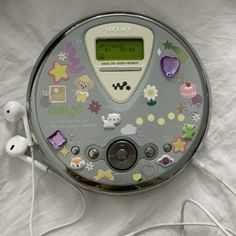 an electronic device with many stickers on it's face and earbuds