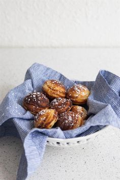 a basket filled with donuts covered in powdered sugar on top of a table