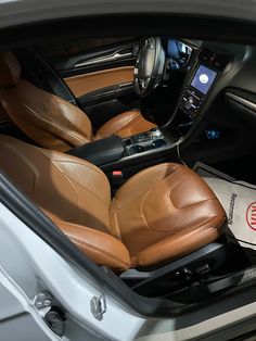 the interior of a car with brown leather seats and electronic equipment in it's center console