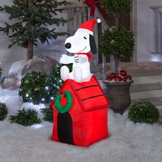 a large inflatable christmas decoration with a dog sitting on top of the house