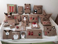 many brown bags with christmas decorations on them are sitting on a table in front of a white wall