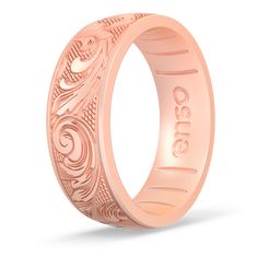 the rose gold wedding band is engraved with an ornate design and has a name on it