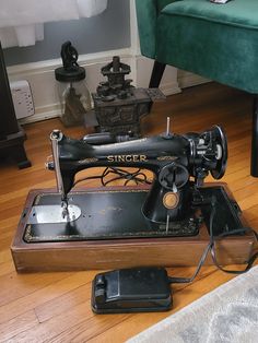 an old sewing machine sitting on top of a wooden floor