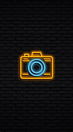 a neon camera on a brick wall