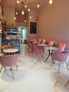 the inside of a restaurant with pink chairs and tables