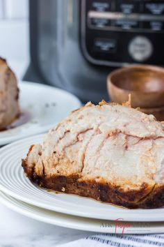 a piece of meat sitting on top of a white plate next to an instant pot roaster