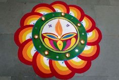 an artistic design on the ground with candles around it for diwaling and decorating