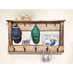 a wooden shelf with hats and headphones hanging on the wall next to a pair of earbuds