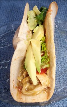 a taco filled with lots of toppings on top of a blue table cloth