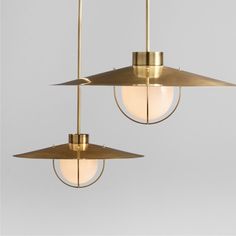 two brass pendant lights hanging from the ceiling