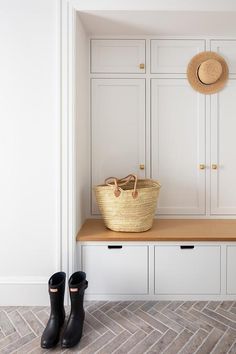 a pair of black boots sitting on top of a wooden bench next to a basket