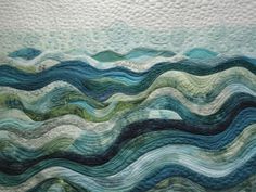 a quilted wall hanging with waves on it