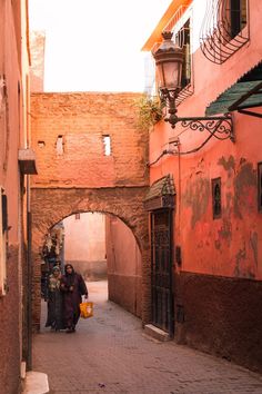 two women are walking down an alley way