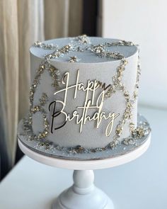 a happy birthday cake with gold and silver decorations