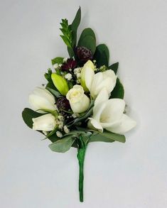 a bouquet of white flowers and greenery on a gray background with space for text