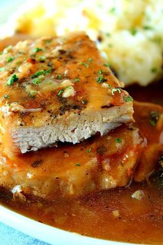 a white plate topped with meat covered in gravy