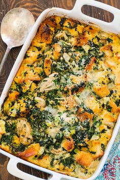 a casserole dish with chicken, spinach and cheese in it next to a spoon