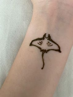 a person with a tattoo on their wrist that has a drawing of a stingfish