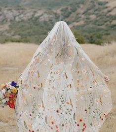 a woman in a white dress with flowers on her veil